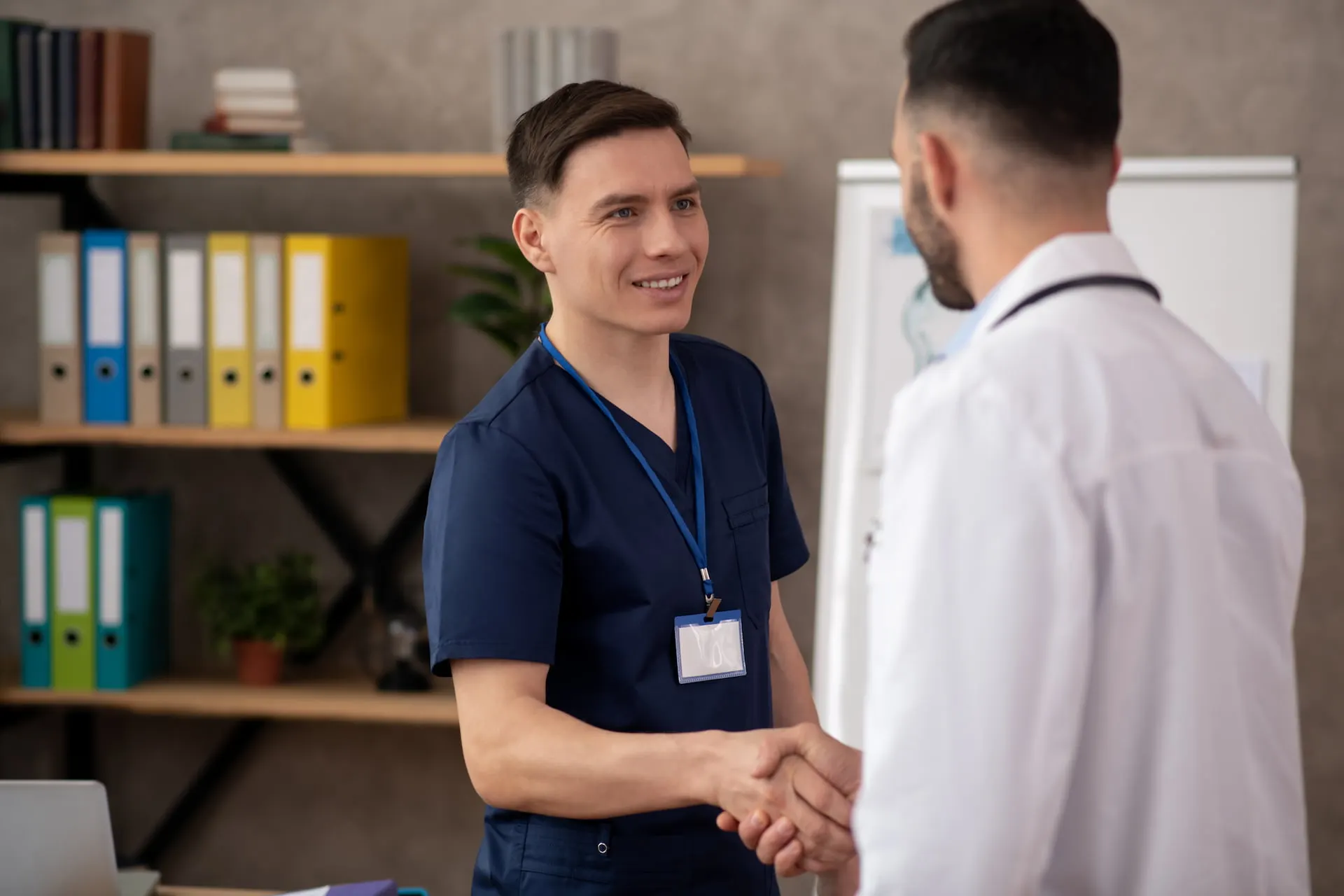 Practice manager shaking hands with a doctor in an office